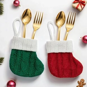 Detail view of red and green knitted Christmas stocking cutlery holders on a festive table