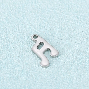 Pendentif note de musique en acier inoxydable argenté poli sur fond de tissu bleu