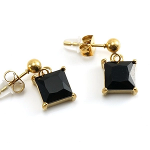 Detailed close-up of 18K gold earrings featuring a square black zircon gemstone