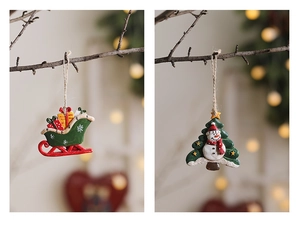 Close-up of resin Christmas tree ornaments featuring Santa on a green sled and a snowman