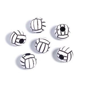 Close-up of six white acrylic volleyball beads with black stitch detail for DIY jewelry