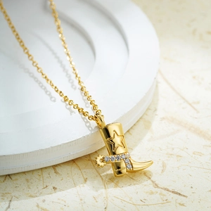 Detailed macro view of 18K gold plated cowboy boot pendant with star pattern and zircons
