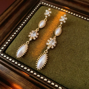 Vintage gold tassel earrings with pearls and zircon on a green velvet box