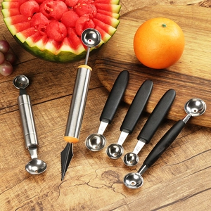 Stainless steel fruit scooper and carving set on wooden table with fresh fruits