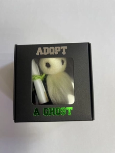Close-up of handmade felt ghost doll in a black Adopt A Ghost gift box with scroll
