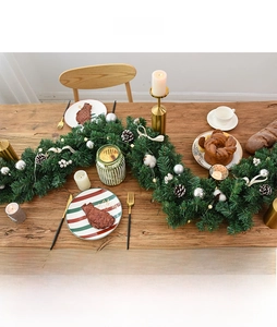 Close-up of 2.7m Christmas garland with pine cones and white berries on a festive dining table