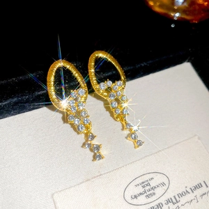Macro shot of sparkling silver needle fringe earrings with rhinestones on a card
