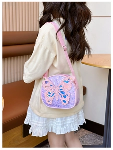 Detail of sequins and 3D glitter butterfly on girls purple crossbody bag shown on model