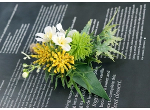 Detailed view of white artificial boutonniere with green leaves and jute twine wrapping