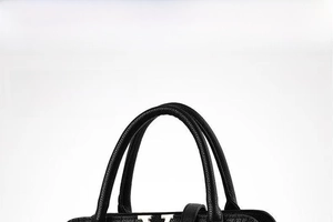 Close-up of black litchi grain leather handbag with silver V-shaped metal hardware detail