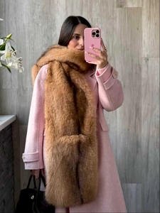 Close-up of fluffy brown faux fox fur scarf paired with a stylish pink winter coat
