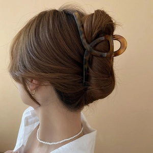 Detail of large tortoiseshell hair claw clip securing thick hair on a female model
