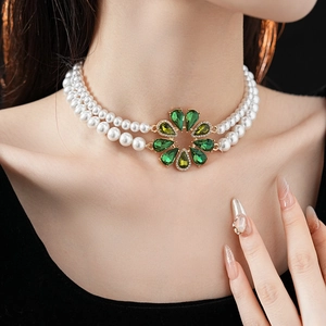 Dettaglio della collana di perle a due strati con ciondolo a fiore in pietra verde