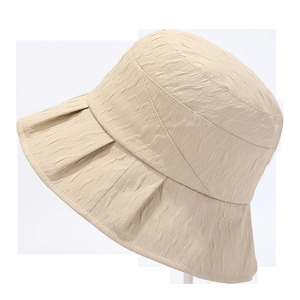 Detail of beige bucket hat featuring a unique pleated texture and wide sun protection brim