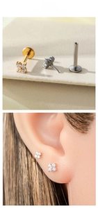 Detailed view of titanium clover labret stud with zircon stones and flat back design