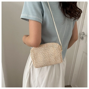 Detailed back view of a beige straw woven crossbody bag with a slim shoulder strap
