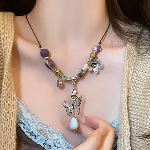 Detail of vintage beaded necklace with butterfly pendant and colorful stones on model