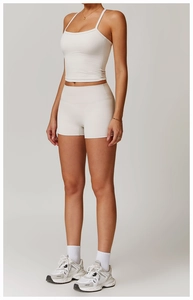 Dettaglio del set sportivo con pantaloncini yoga a vita alta e canotta color crema