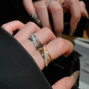 Close-up of elegant three-layer criss-cross rings with pavé zircon stones and polished metal