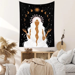 Detail of Bohemian goddess tapestry with sun and moon phases hung in a minimalist bedroom