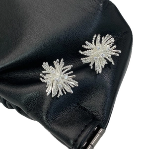 Sparkling silver starburst stud earrings with zircon crystals on black leather backdrop