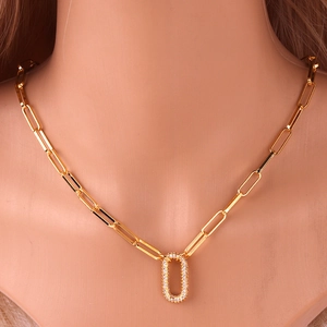 Detail of gold-plated paperclip chain necklace with a crystal oval pendant on a model