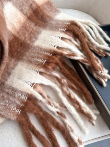 Detail shot of brown and beige plaid scarf with soft texture and long tassels fringe