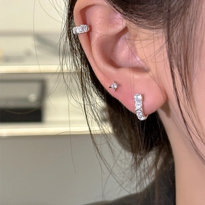Silver U-shaped earring set with cubic zirconia featuring stars and hoops on model