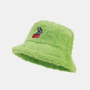 Close-up of fluffy green faux fur bucket hat with detailed red cherry embroidery
