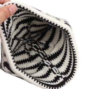 Vue intérieure du bonnet en tricot rayé noir et blanc montrant une texture chaude
