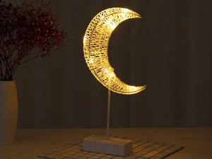 Detail of warm LED moon lamp with woven rope texture on a wooden base for home decor