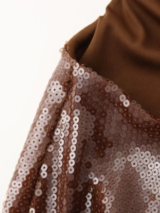 Macro de paillettes brunes sur l'épaule d'une robe de soirée sexy avec dos nu élégant
