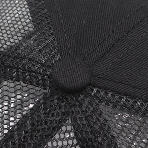 Macro shot of the crown detail and mesh structure on the black outdoor trucker cap