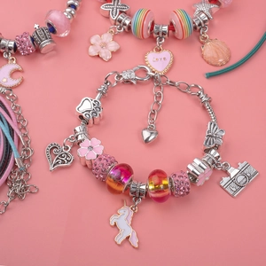 Detail of pink unicorn DIY charm bracelets with glass beads and enamel pendants