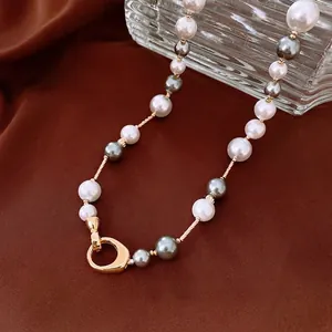 Élégant collier de perles plaqué or avec perles blanches et gris-bleu sur soie brune
