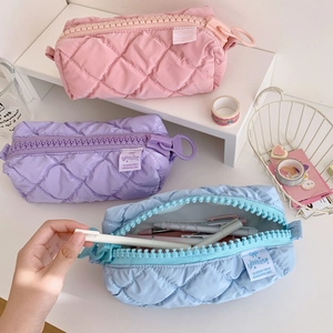 Quilted pastel pencil cases in pink, purple, and blue with large zippers and soft texture