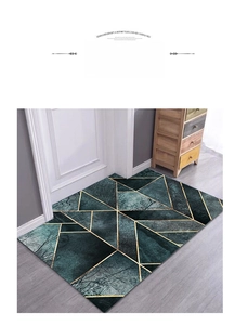 Detail of dark green modern doormat with gold geometric lines on a wooden floor