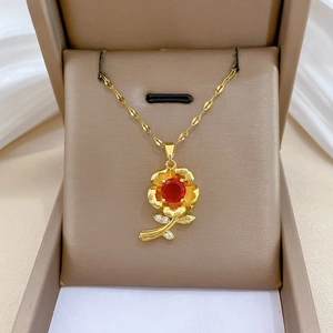 Detail of red rose pendant with sparkling crystals and gold chain in a jewelry box