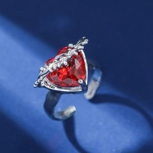 Detailed close-up of heart-shaped red gemstone ring with thorny silver adjustable band