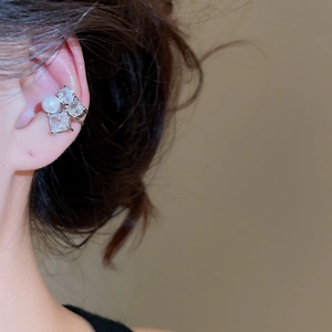 Detail of silver ear cuff with pearls and zircons shown on model side ear view