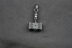 Detailed macro shot of vintage stainless steel Viking hammer pendant with intricate patterns