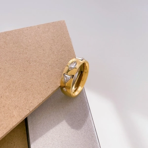 Detail of a gold-plated wide band ring featuring marquise and round zircon stone inlays