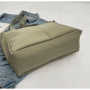 Detail of beige canvas shoulder bag textured material placed on a blue denim jacket