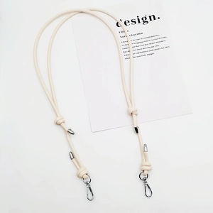 Close-up of cream leather crossbody strap with silver metal spring hook and knot detail