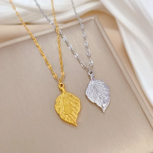 Minimalist titanium steel leaf pendant necklace in gold and silver on silk background