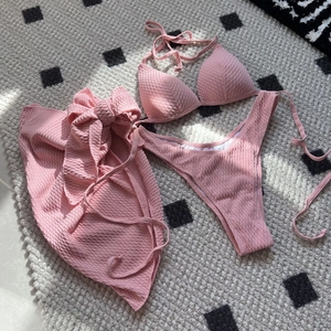 Chic pink three-piece bikini set with high-waist sarong and textured seersucker fabric