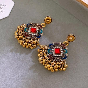 Details von Vintage-Blumen-Ohrringen mit roten Steinen und Emaille auf grauem Tablett