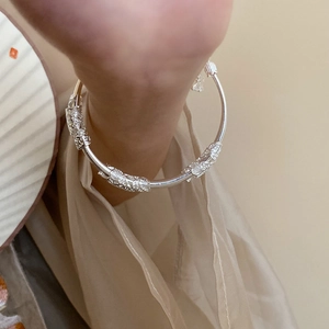 Detailed close-up of a silver lotus bamboo open bangle with embossed textures on a wrist