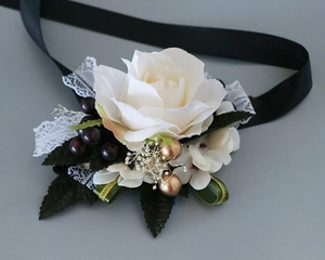 Détail d'un bracelet de fleurs en rose blanche artificielle avec dentelle et perles