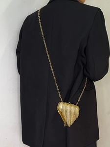 Detailed view of luxury gold rhinestone mini bag with fringe and elegant chain strap